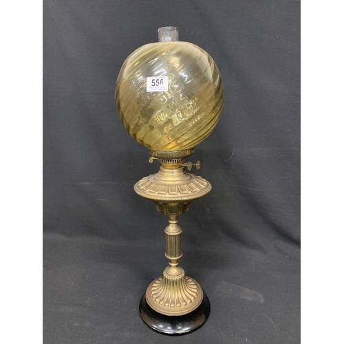 556 - Oil lamp on brass base, height 68cms