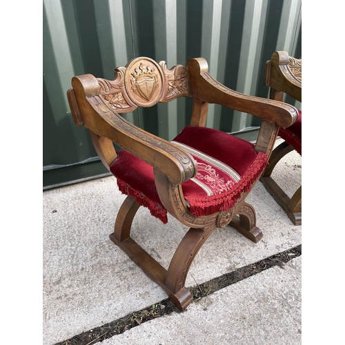 1 - A pair of carved oak x frame throne style chairs with red upholstered seats