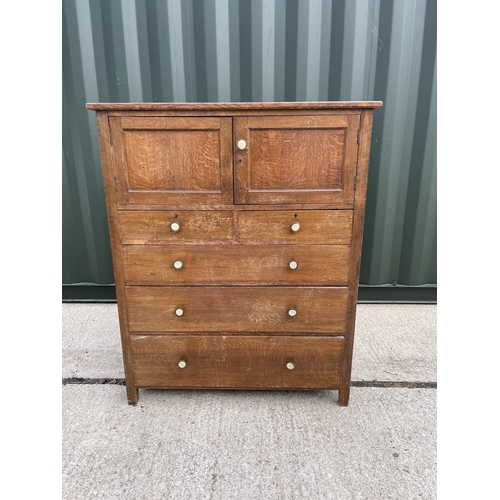 10 - An early 20th century oak linen press cupboard with two door cupboard over five drawers