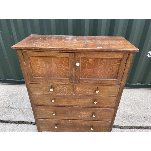 10 - An early 20th century oak linen press cupboard with two door cupboard over five drawers