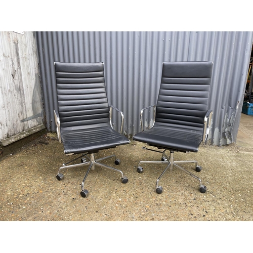 114 - A pair of EAMES style designer office swivel chairs, chrome framed with black leather seats