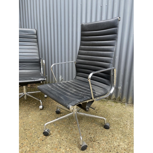 115 - A pair of EAMES style designer office swivel chairs, chrome framed with black leather seats
