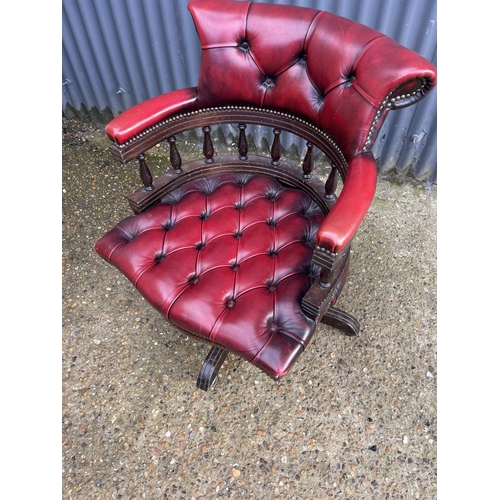 117 - A red leather chesterfield swivel office captains chair
