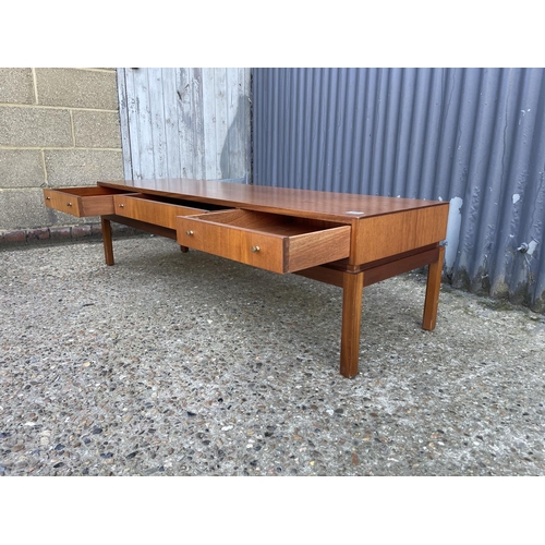 124 - A teak coffee table with three two way drawers by Greeves and Thomas