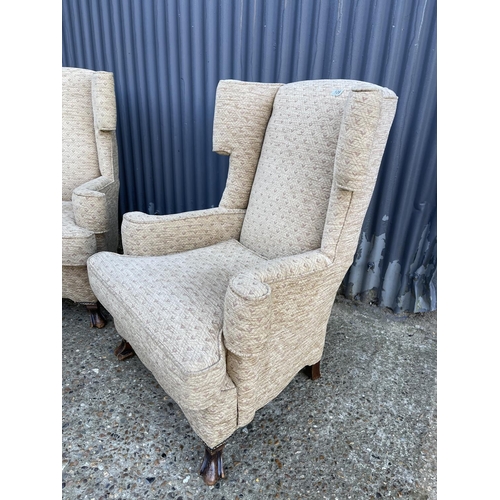128 - A pair of cream upholstered wing back armchairs