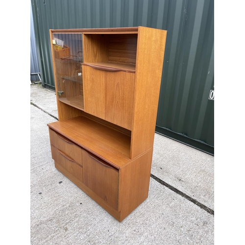 13 - A compact size two section teak cocktail unit with glazed door and shelves