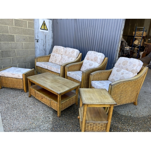 146 - A rattan style six piece conservatory suite consisting of a sofa, two chairs, coffee table, side tab... 