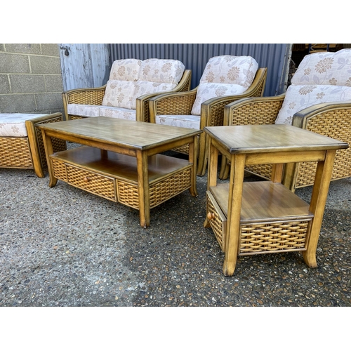 146 - A rattan style six piece conservatory suite consisting of a sofa, two chairs, coffee table, side tab... 