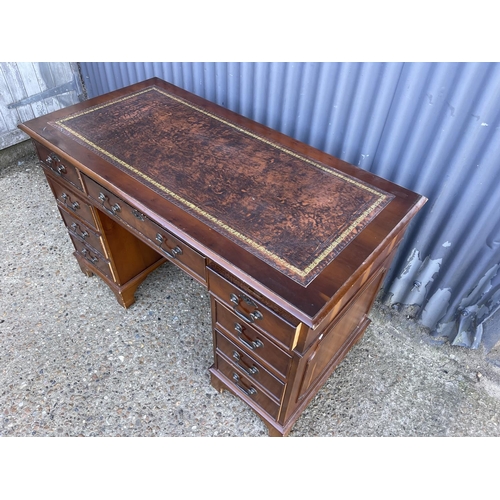 167 - A reproduction yew pedestal desk with a brown leather top