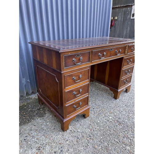 167 - A reproduction yew pedestal desk with a brown leather top