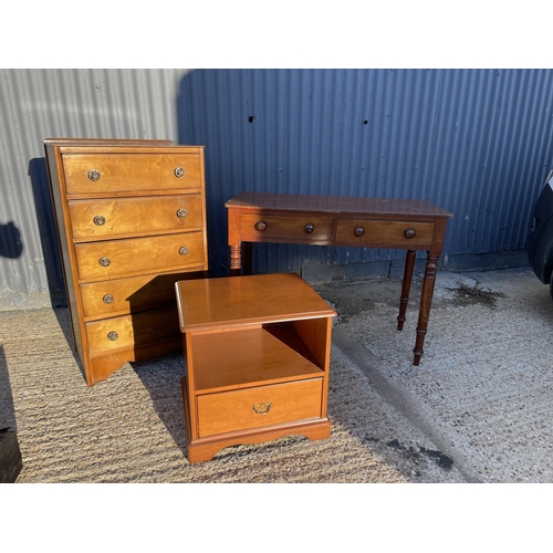 196 - An oak chest of five, a mahogany two drawer writing table and a stag bedside