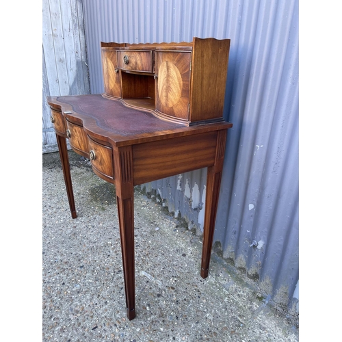 207 - A reproduction mahogany ladies writing table with a brown leather top