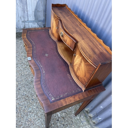 207 - A reproduction mahogany ladies writing table with a brown leather top