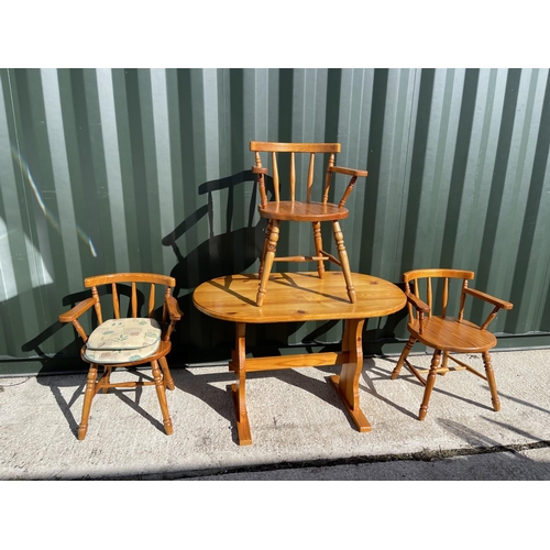 22 - A pine kitchen table with three chairs