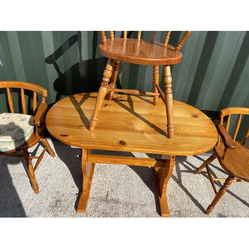 22 - A pine kitchen table with three chairs