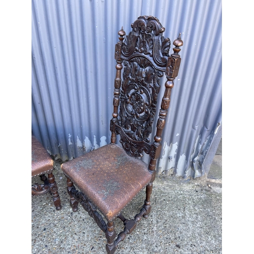 225 - A pair of carved oak chairs with brown leather seats embossed with dragons