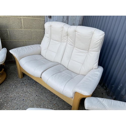 232 - A STRESSLESS cream leather three piece suite BY EKORNES consisting of a two seater sofa, two armchai... 