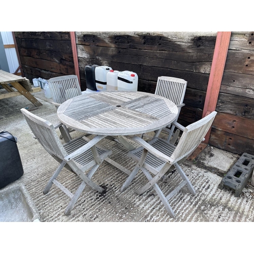 437 - A circular hardwood garden table together with four carver chairs