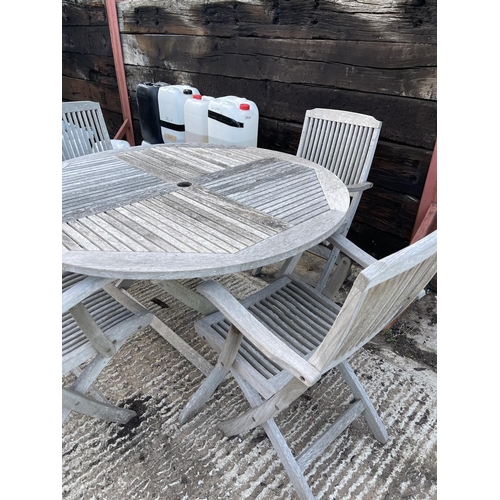 437 - A circular hardwood garden table together with four carver chairs