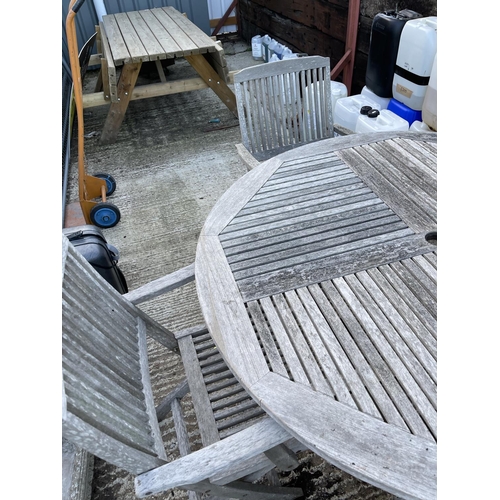 437 - A circular hardwood garden table together with four carver chairs