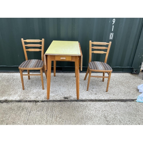 47 - A yellow formica kitchen table with drawer together with two chairs