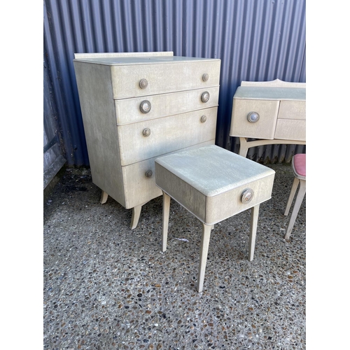 16 - A mid century bedroom suite consisting of a chest of drawers, four drawer desk, a bedside and a stoo... 