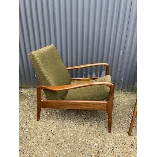 170 - A pair of mid century teak framed lounge chairs labelled GREAVES AND THOMAS with green upholstery