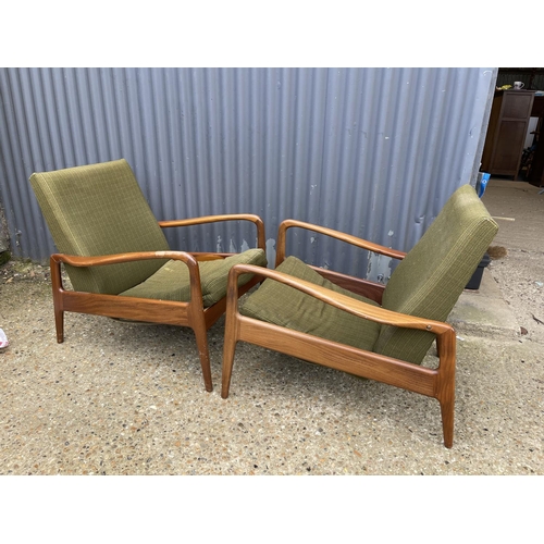 170 - A pair of mid century teak framed lounge chairs labelled GREAVES AND THOMAS with green upholstery