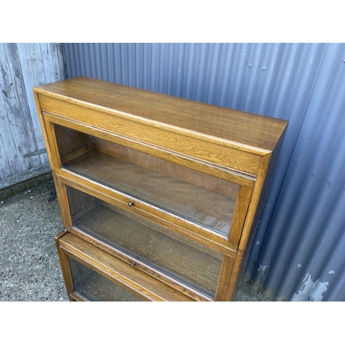 174 - An oak three section stacking bookcase with glazed up and over doors