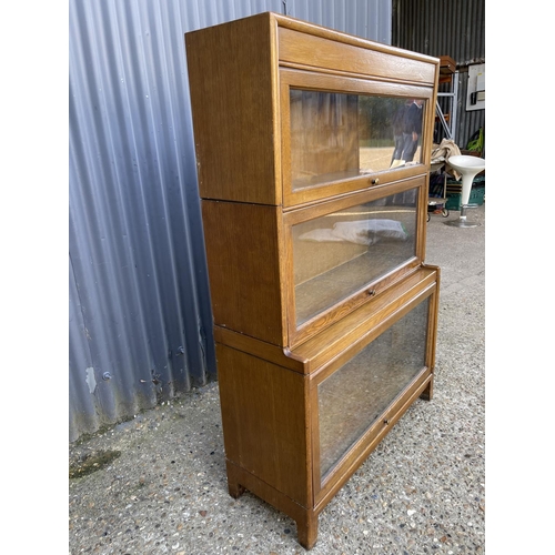 174 - An oak three section stacking bookcase with glazed up and over doors