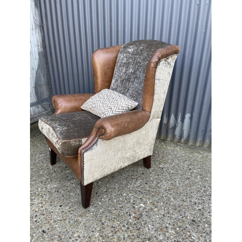 177 - A tan brown leather wing back armchair with crush velvet seat by TETRAD