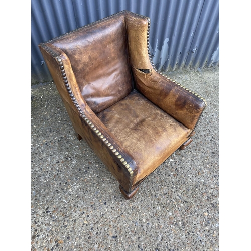 182 - A tan brown leather club style chair with brass studs