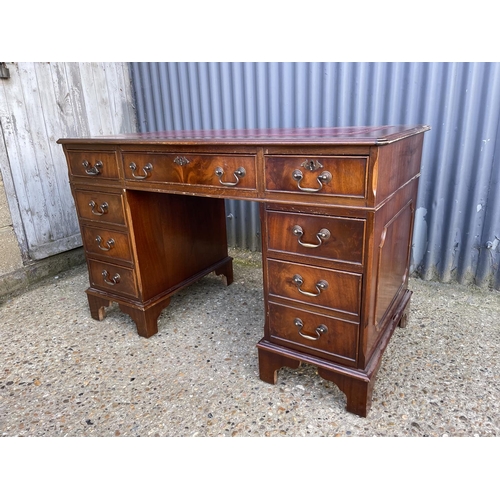 189 - A reproduction mahogany twin pedestal desk with a red leather top