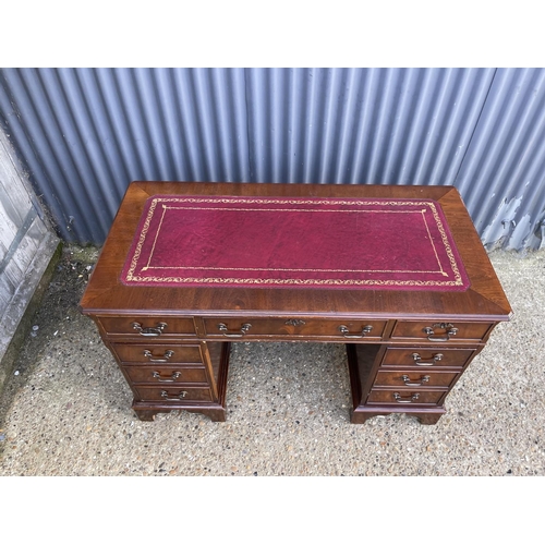 189 - A reproduction mahogany twin pedestal desk with a red leather top