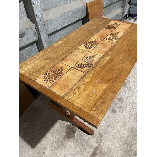 199 - An extending teak dining table with two leaves. Tile decoration to the middle