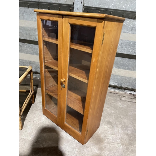 214 - A pine two door cabinet together with a bamboo and glass table