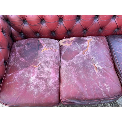 257 - An oxblood red leather chesterfield sofa for reupholstery