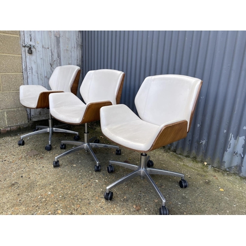 281 - Three EAMES STYLE cream upholstered swivel office chairs BY BOSS