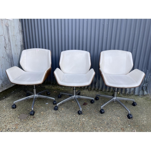 282 - Three EAMES STYLE cream upholstered swivel office chairs BY BOSS