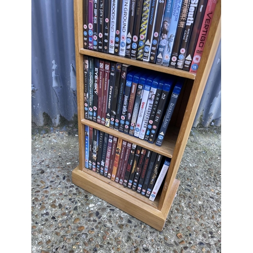 34 - A modern light oak shelf filled with dvd's and blue ray disks