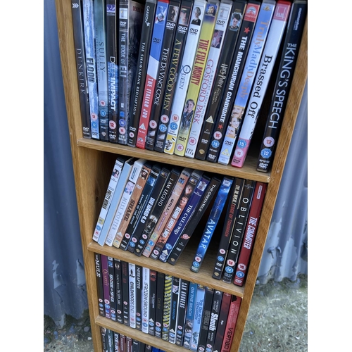 34 - A modern light oak shelf filled with dvd's and blue ray disks