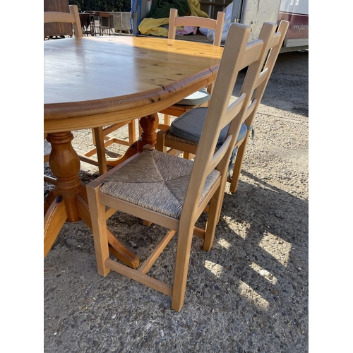 40 - An extending ducal pine dining table together with six farmhouse style ladder back chairs with drop ... 