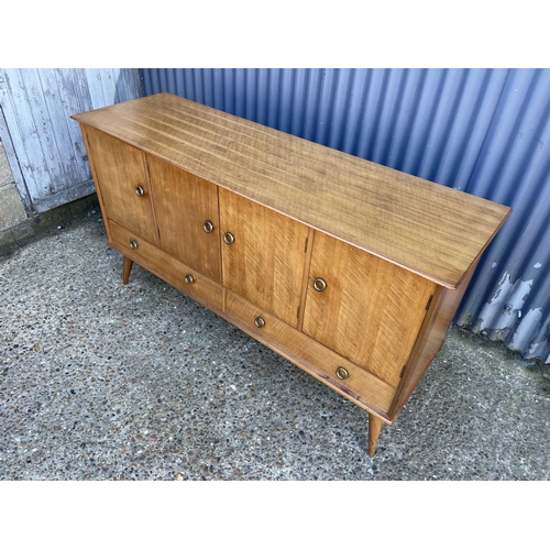 66 - A mid century four door and two drawer sideboard in French walnut by YOUNGER retailed and labelled H... 