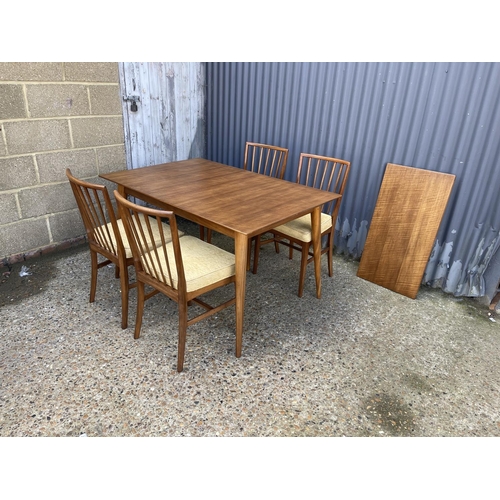 67 - An extending rectangular dining table with one leaf and four original matching dining chairs by YOUN... 