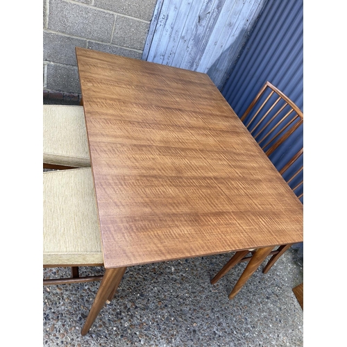 67 - An extending rectangular dining table with one leaf and four original matching dining chairs by YOUN... 