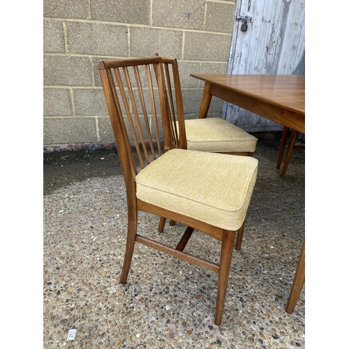 67 - An extending rectangular dining table with one leaf and four original matching dining chairs by YOUN... 