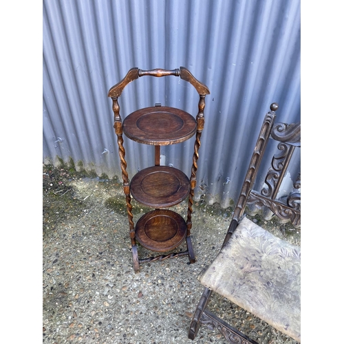 76 - A carved folding chair and a folding cake stand