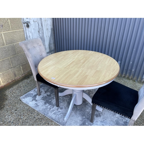 80 - A modern circular extending table together with two high back chairs and a silver rug