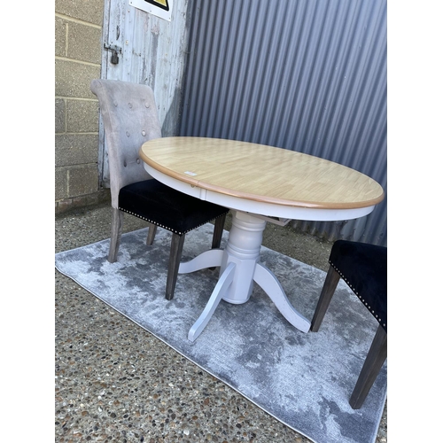 80 - A modern circular extending table together with two high back chairs and a silver rug