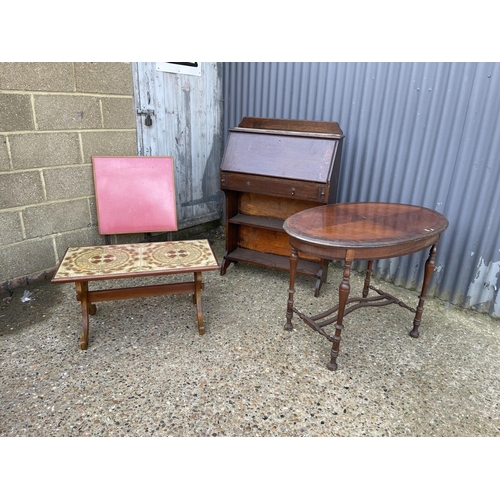 96 - An oak students bureau, oval occasional table, tile top table and a folding card table